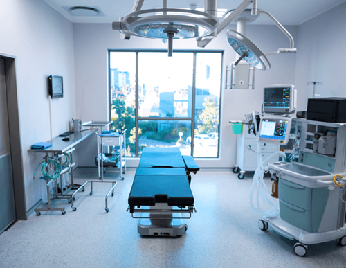A hospital room with a table and several medical equipment.