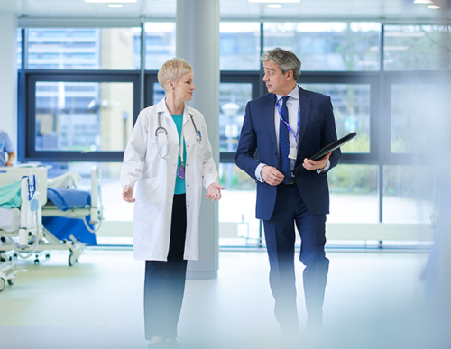 Two doctors are standing in a hospital room.